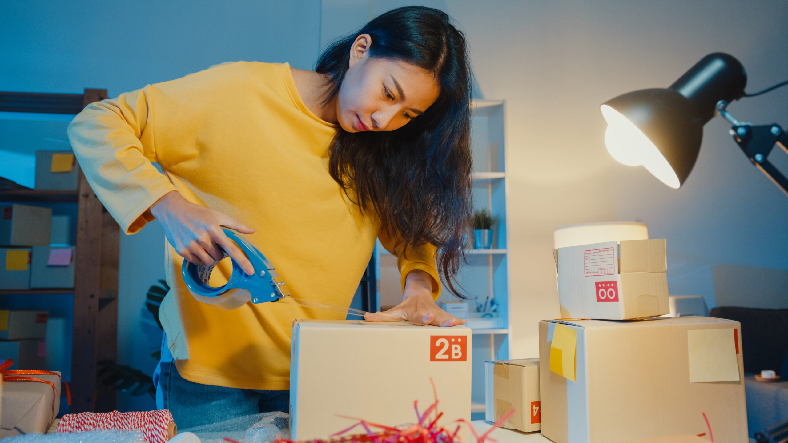 Young Asia businesswoman prepare product use tape packing box fo